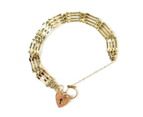 A yellow metal four-bar gate bracelet with a heart-shaped padlock stamped 375, approx 7.5g.