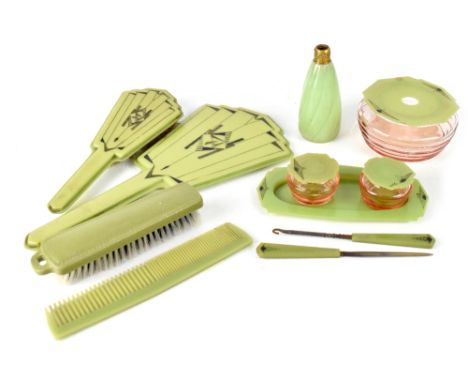 A 1930s Art Deco green Bakelite dressing table set comprising hand mirror, two brushes and a comb, two salmon-coloured glass 