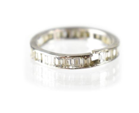 A white gold diamond eternity ring set with thirty small baguette cut diamonds, size O. CONDITION REPORT There should be 32 d