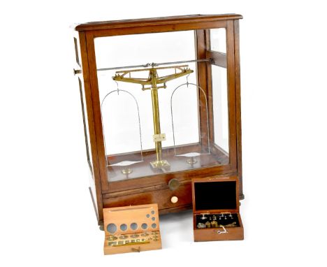 A cased set of Oertling brass apothecary scales within a glazed oak case, height 56cm, width 43cm, a J Towers &amp; Co Ltd bo