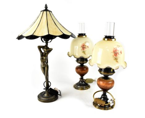 A set of four matching table lamps in the form of oil lamps, with brass and wood bases and floral painted glass shades, heigh