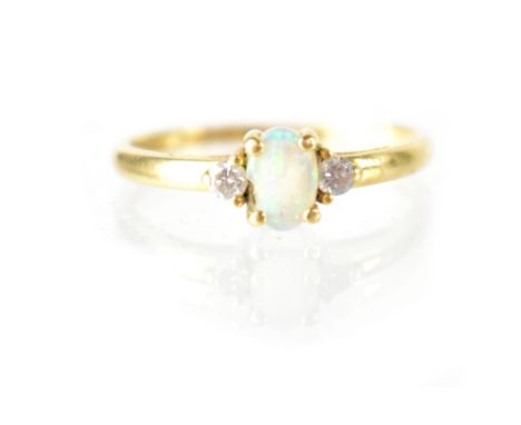 An 18ct yellow gold opal and diamond ring, central white opal flanked by two small brilliant diamonds, size M, approx 1.6g.