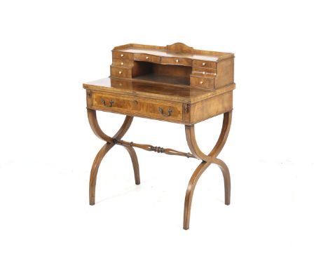 A 19th century burr walnut writing table. The raised serpentine fronted ledge having two long drawers to the centre flanked b