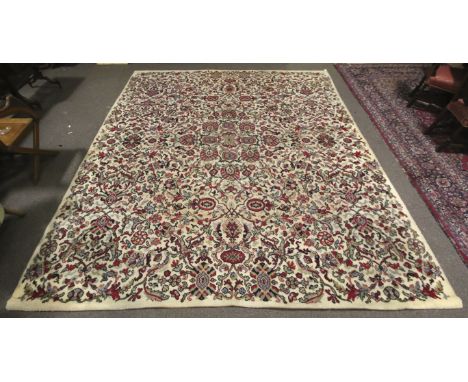 A vintage woollen rug. The pink, green and blue floral and foliage pattern on a cream ground, 366cm x 315cm