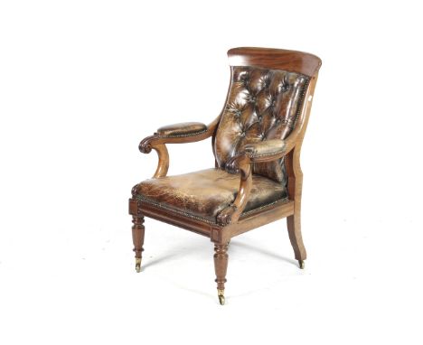 A 19th century mahogany framed library armchair. Upholstered in brown leather with a button back and brass studded details, h