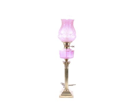 A early 20th century oil lamp converted for electric use. Having a clear glass funnel and pink opaline glass moulded shade fe