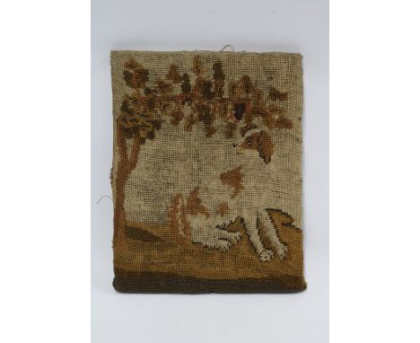 A small antique tapestry of a Spaniel under a tree, tacked on a stretcher, 31 x 25cm 