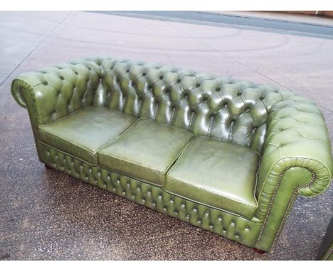 A green leather button back armchair (see also lot 59)