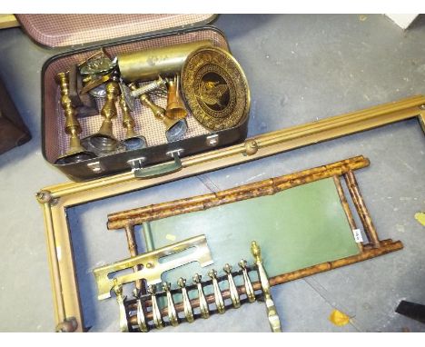 A vintage suitcase containing a quantity of brass ware to include candlesticks, flat iron, brass grate and a brass fire surro
