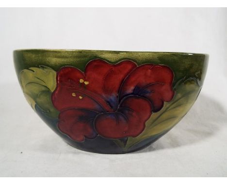 A Moorcroft Pottery oval planter decorated with coral hibiscus on a green ground, paper label to base, 8.5 cm (h) x 16.5 cm (