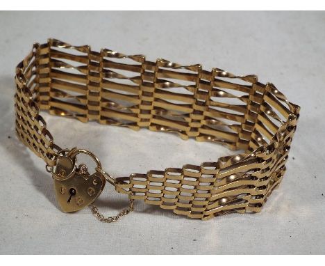 A lady's 9 carat gold gate bracelet with 9 carat gold padlock and chain, approximate weight 18.18 grams, Estimate £150 - £180