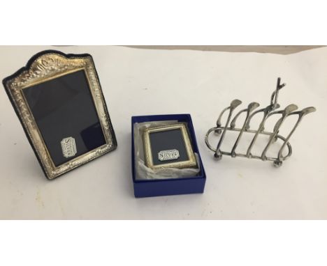 A silver novelty wishbone toast rack in silver by R&B, c1924; together with two silver photograph frames