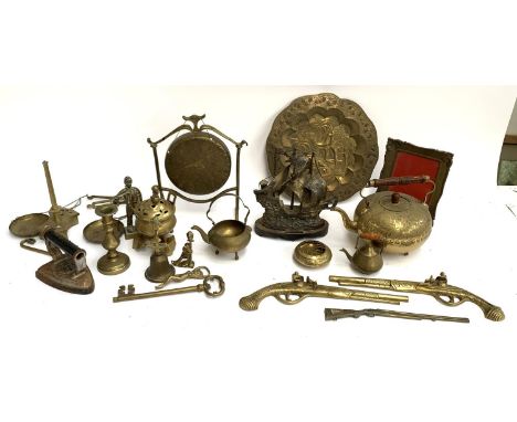 A mixed lot of brass items to include gong, kettle, charger, model ship, bottle opener, flintlock pistol plaques, iron candle