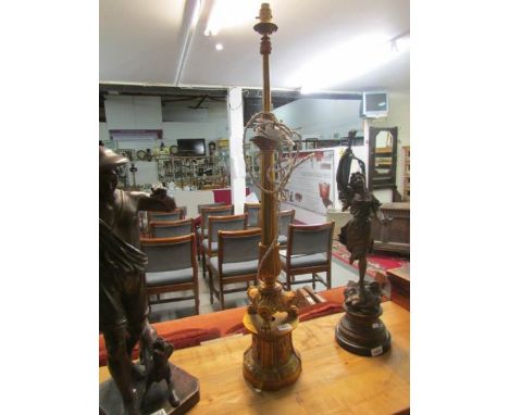 A tall ornate gilded table lamp