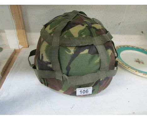 A British army helmet with khaki camouflage cover