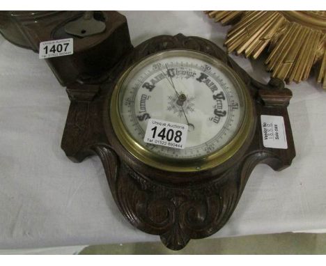 A carved oak barometer