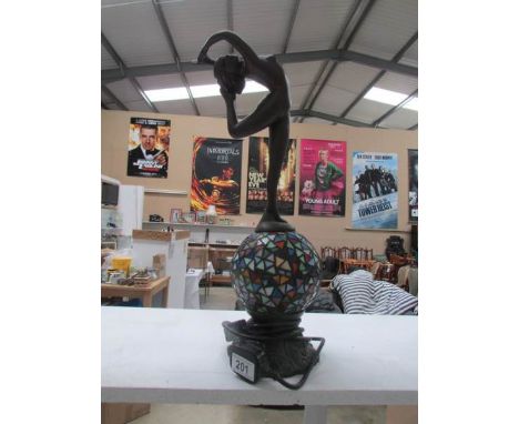 A table lamp in the form of an Art Deco style figure standing on a leaded glass ball