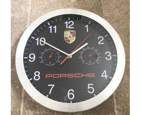 A Porsche-themed wall clock having a Quartz movement. Black ground with batton hands, sweep seconds hands, subsidiary thermom