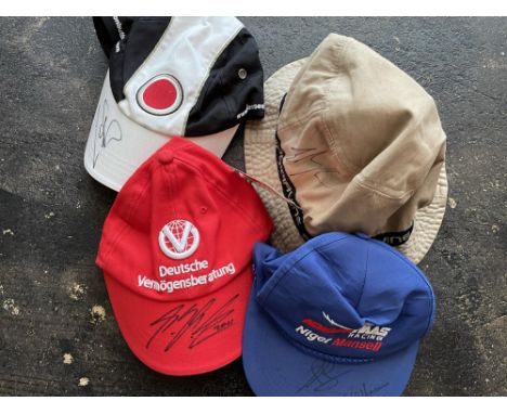 Signed by Michael Schumacher, Jenson Button, Nigel Mansell and Eddie Irvine.Three baseball caps and a 'Beanie' signed by Mich