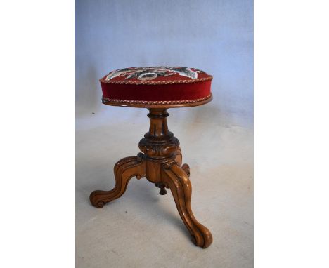 A Victorian carved walnut piano stool in original tapestry upholstery. H.42 W.30cm (Rise and fall mechanism not working). 