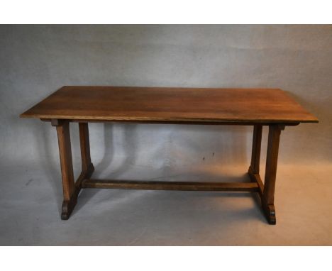 A C.1900 Arts and Crafts oak refectory style dining table on stretchered trestle platform supports. H.76 W.183 D.91cm 