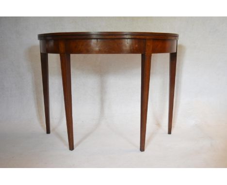 A Georgian mahogany demi lune tea table with fold over top on square tapering gateleg supports. H.73 W.99 D.44 (ext.90cm) 