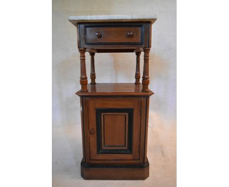 A late 19th century walnut and ebonised pot cupboard with marble top above frieze drawer and fielded panel door on plinth bas