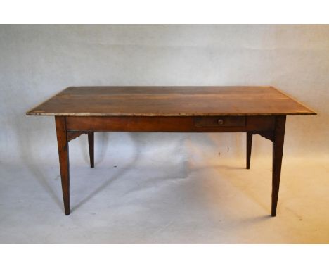 A 19th century pine planked top refectory style dining table with cleated ends and frieze drawer on square section tapering s