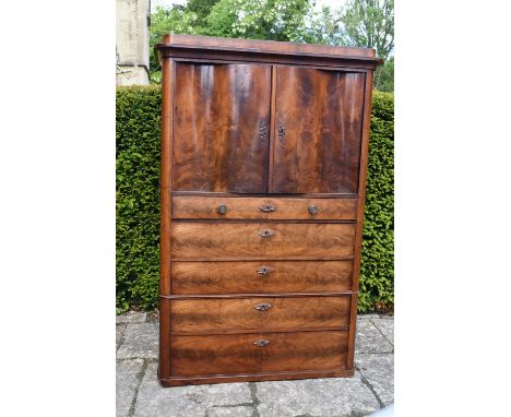 A late 19th century Continental flame mahogany cabinet with serpentine panel doors enclosing fitted interior above five gradu