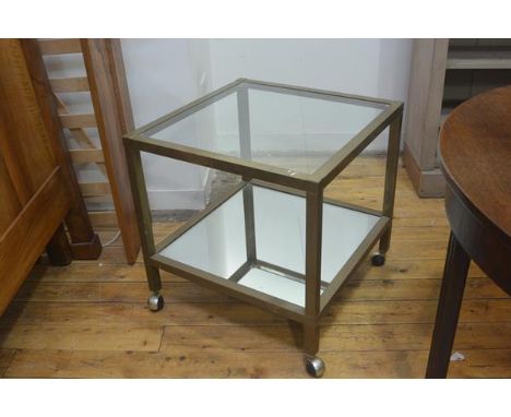 A 1970s brass two tier lamp table with inset glass panel and mirror panel to base, on square supports with chromium plated ba