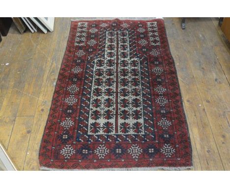 An Afghan prayer rug, the shaped panel with stylised leaf design enclosed within a multiple flowerhead and leaf border, red f