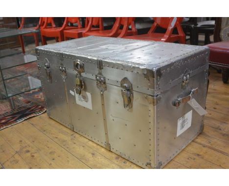 A post war American aluminium travel trunk with studded top, fitted blue lined tray and interior, with leather carry handles 