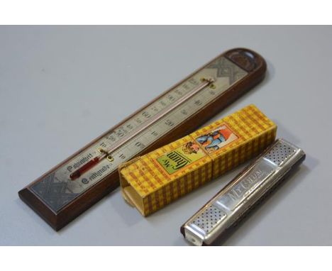 An Edwardian oak wall thermometer with engraved silvered plate (l. 28cm) and a My Chum German mouth organ complete with origi