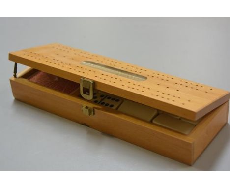 A modern pine gentleman's brass mounted games compendium, complete with dominoes, cribbage board, playing cards (unopened)