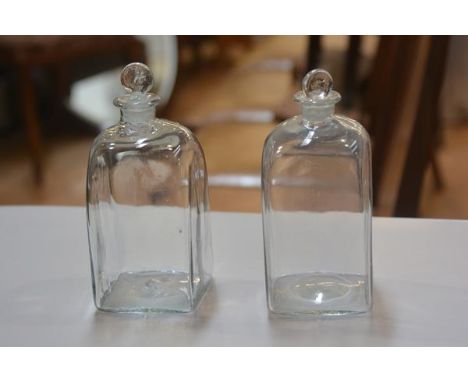 A pair of 18thc clear glass gin bottles complete with original stoppers (h.30cm)