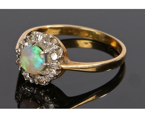 Opal and diamond set ring, with a central opal and round cut diamond surround, ring size U