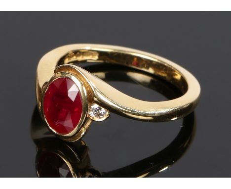 18 carat gold ruby and diamond set ring, the central oval ruby with a diamond to either side, ring size O