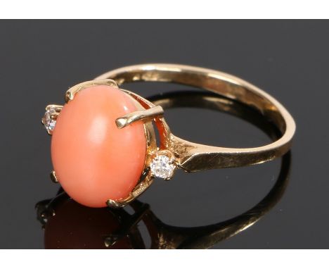 Gold coral and diamond set ring, with a central coral flanked by a round cut diamond to the sides, ring size N