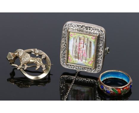 Silver and enamel brooch, the central enamel panel with a winged cherub in a garden, 31mm high, together with another brooch 