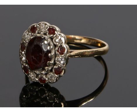 18 carat gold diamond and garnet set ring, with a central garnet with diamond and garnet surround, ring size T