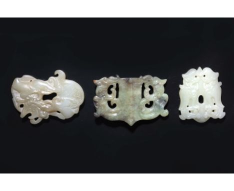 A GROUP OF THREE JADE CARVINGS (1)
A pale celadon pendant modelled as two chilong climbing over an object, a celadon-green ru