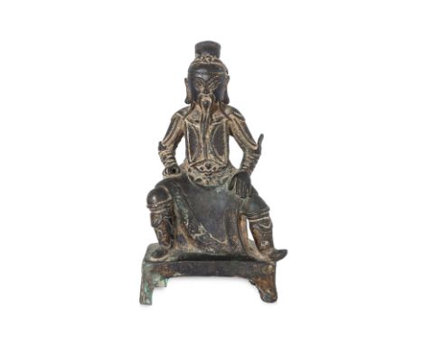 A SEATED GILT BRONZE FIGURE OF GUANDI ON STAND 16th/17th Century, modelled sitting with legs apart and arms resting on thighs