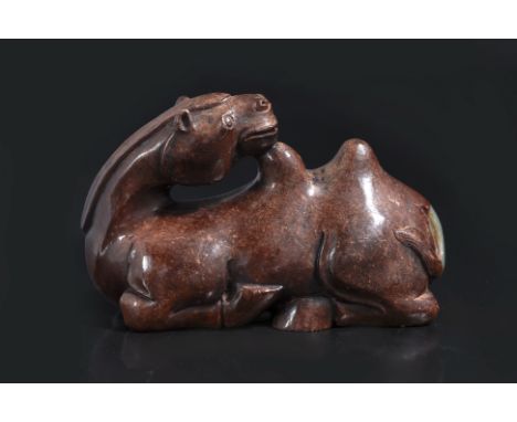 A JADE CARVING OF A RECUMBENT CAMEL
Brown and celadon Hetian jade modelled with head facing backward, rested on hump, seated 
