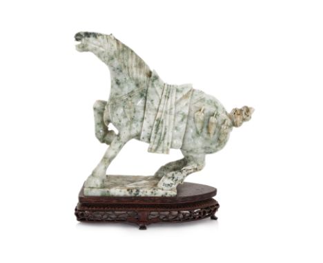 A CARVED JADE MODEL OF A HORSE
The white/grey stone with mottled green inclusions, the horse modeled with it's head and one f