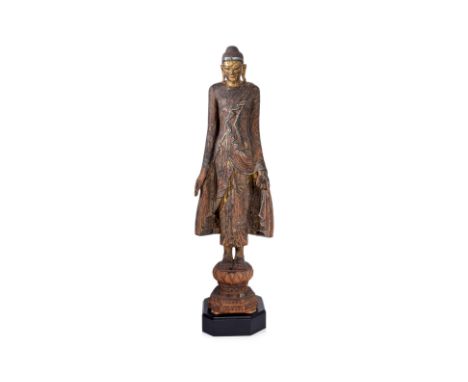 A LARGE BURMESE STANDING LACQUERED BUDDHA
Circa 17th/18th century, lacquered wood with gilding and inset circular coloured gl