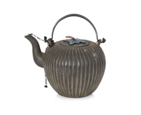 A SMALL PEWTER AND ENAMEL FLUTED TEAPOT 19th/20th Century, the fluted spherical body with swing handle, the cover with foliat