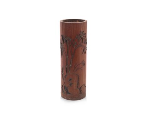 A TALL CARVED BAMBOO BRUSH POT
Carved with bamboo stalks growing from behind a rock, the reverse with calligraphy inscription