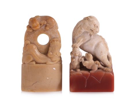 TWO CARVED CHILONG SOAPSTONE SEALS
A red and beige toned example modelled standing and looking backward, a paw on the cub's h