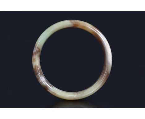 A JADE BANGLE
Celadon green and russet jade bangle with flat interior and slightly rounded exterior
10cm diameter
From the es