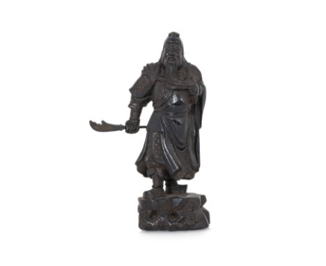 A CARVED HARDWOOD FIGURE OF GUANDI (1)
Qing dynasty, wearing flowing robe over armour and stroking his beard with left hand, 